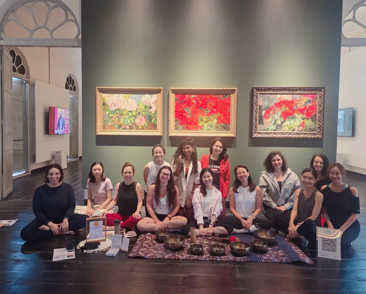 WIFO members at a community wellness session in Singapore, gathered in a gallery space with singing bowls