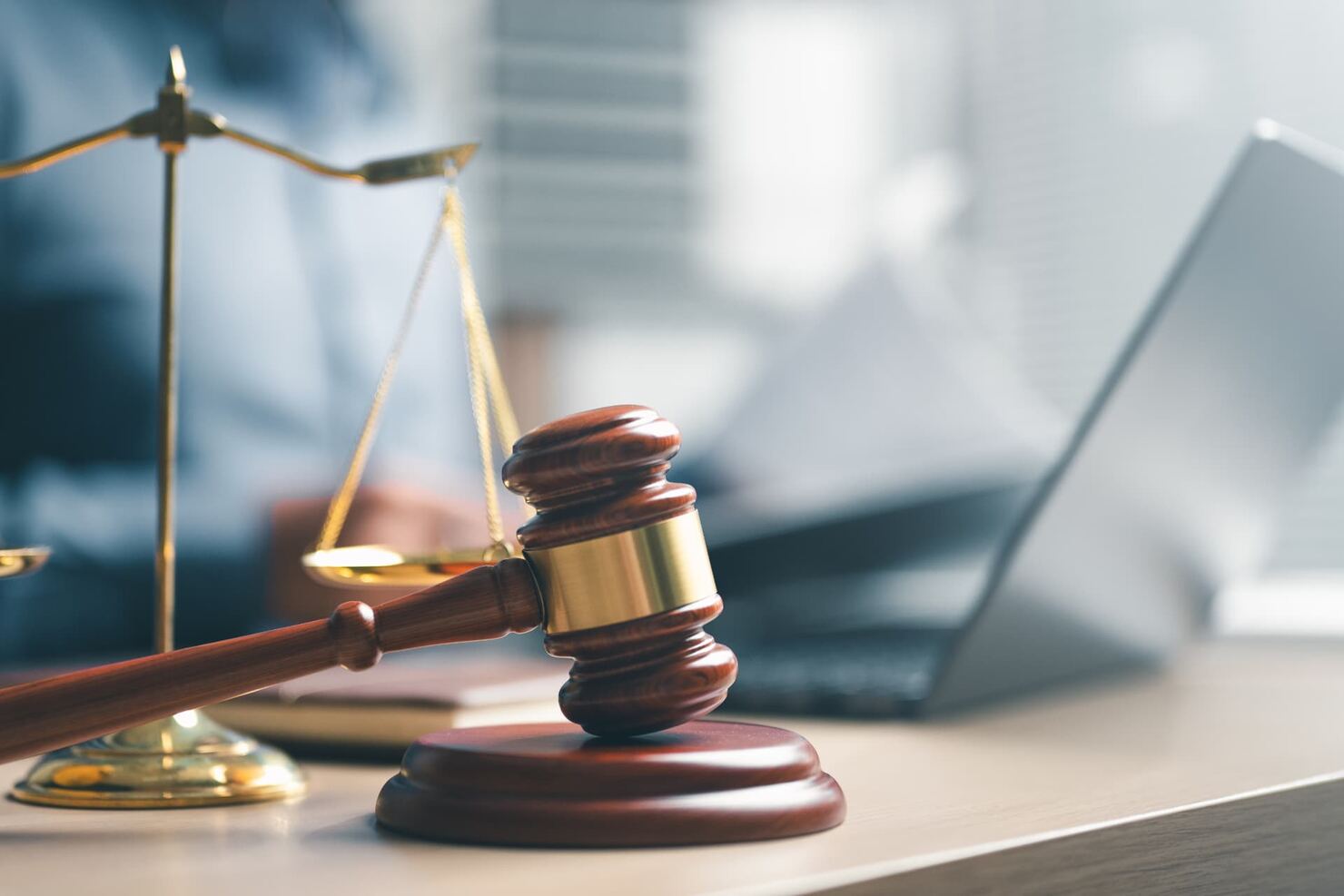 Wooden gavel and scales of justice on a desk