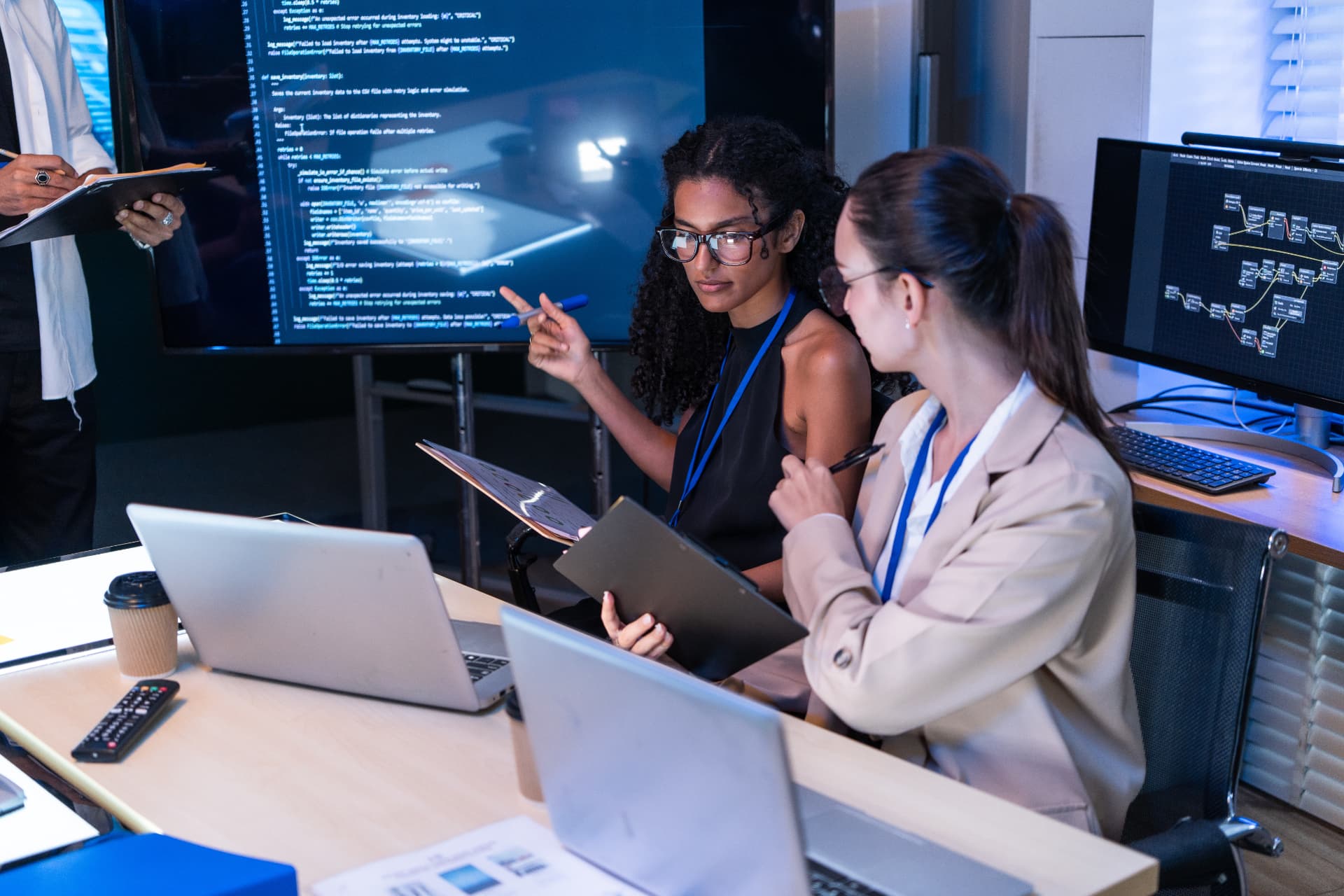 Technology professionals working together with computer systems and data.